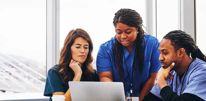 Three healthcare workers explore their new interpreting services together on a computer